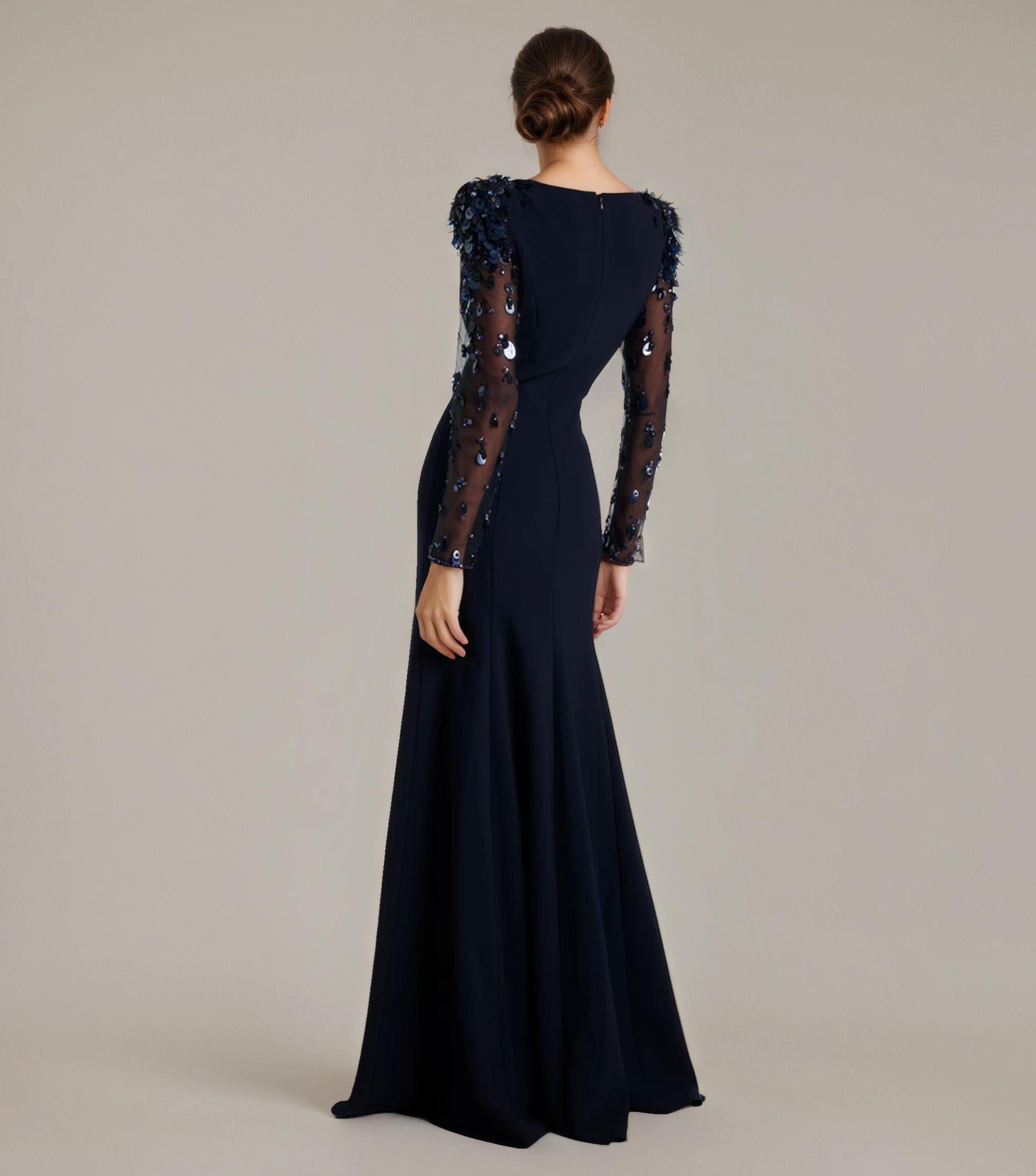 Navy evening gown with lace sleeves on a plain background