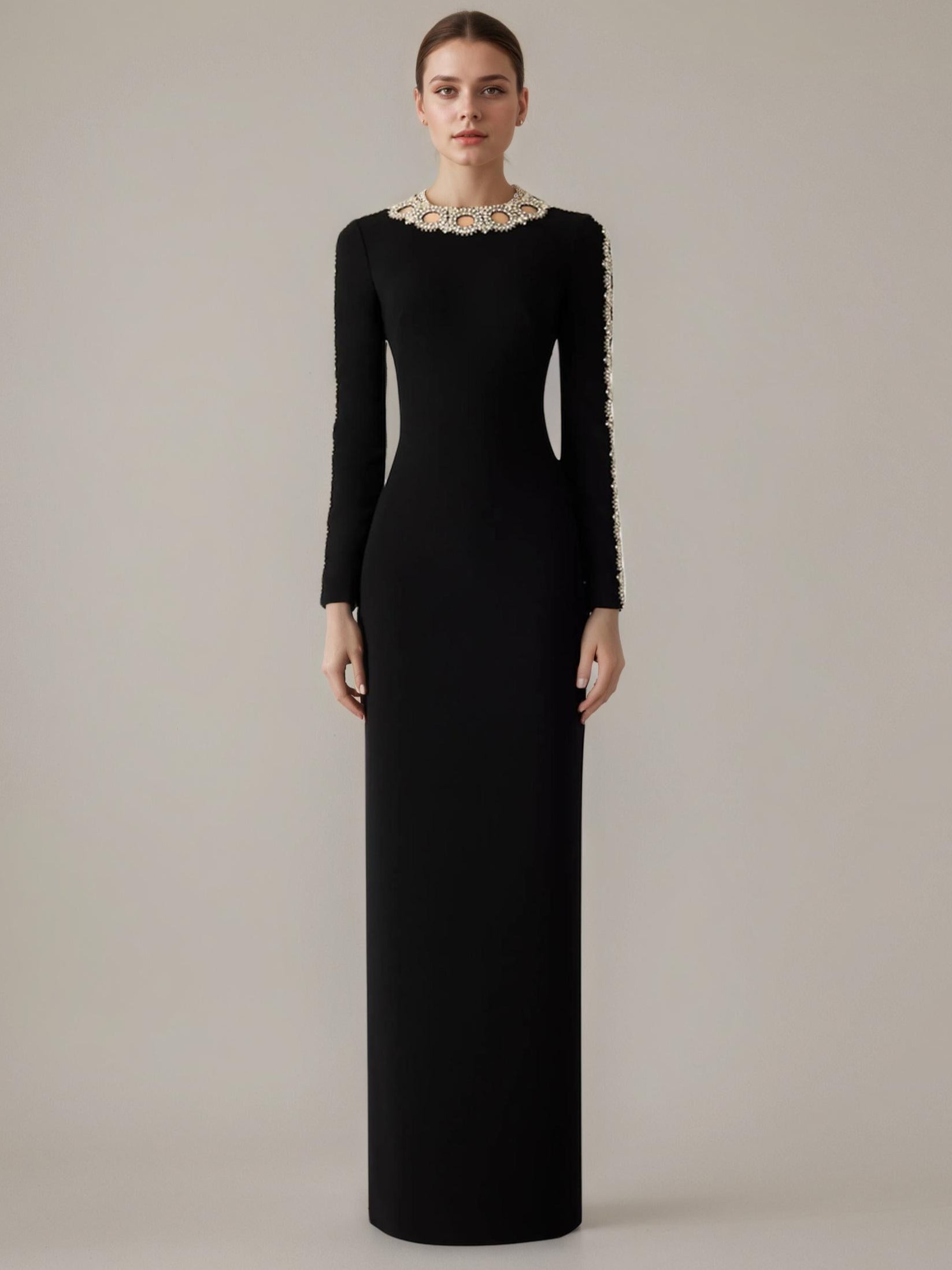 Black evening gown with lace detailing on a plain background
