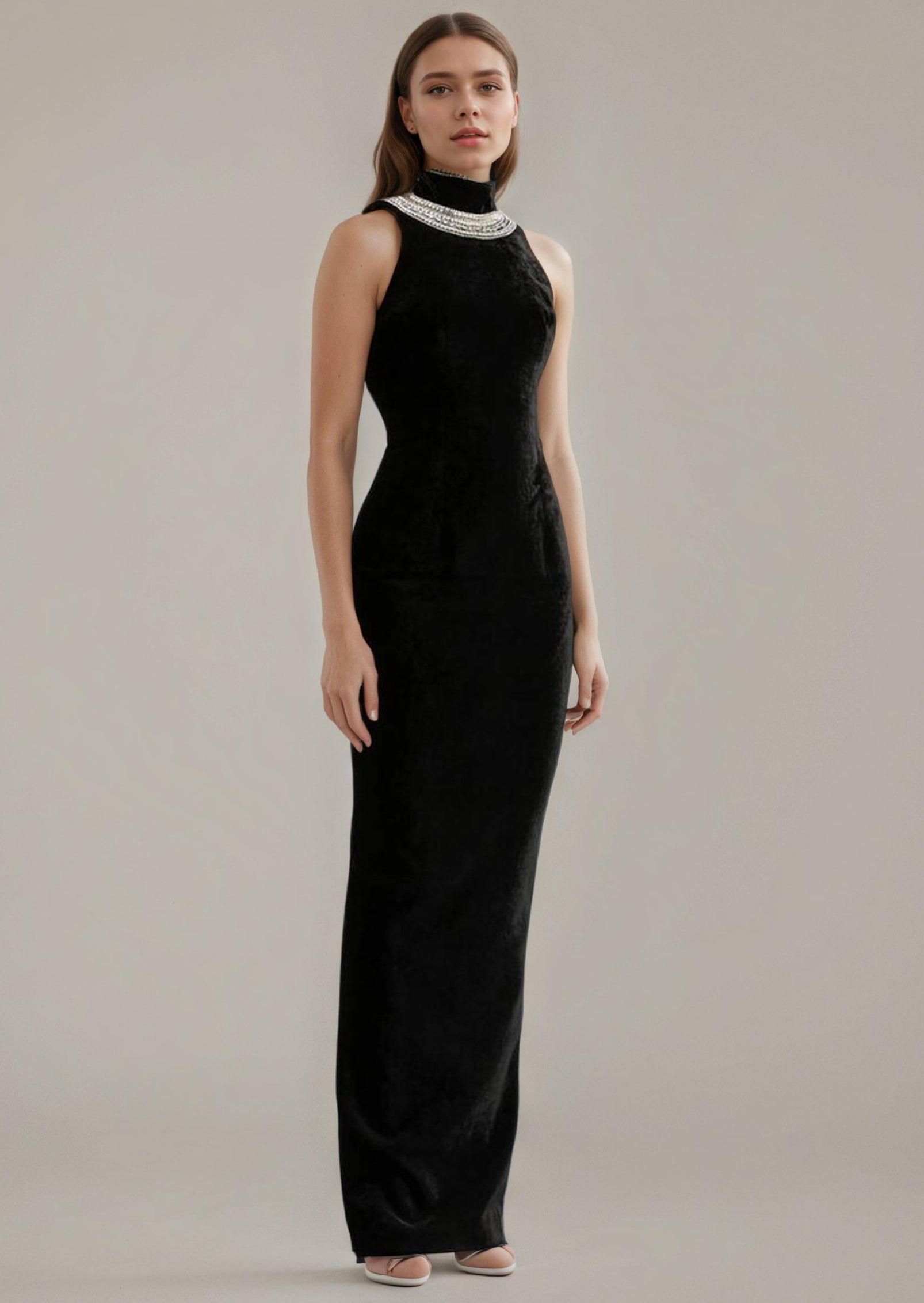 Woman wearing a black evening gown with a high neckline against a plain background