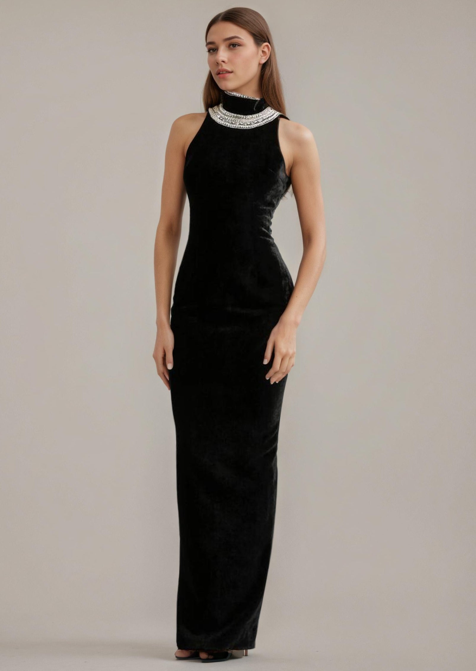 Woman wearing a black evening gown with a high neckline against a plain background