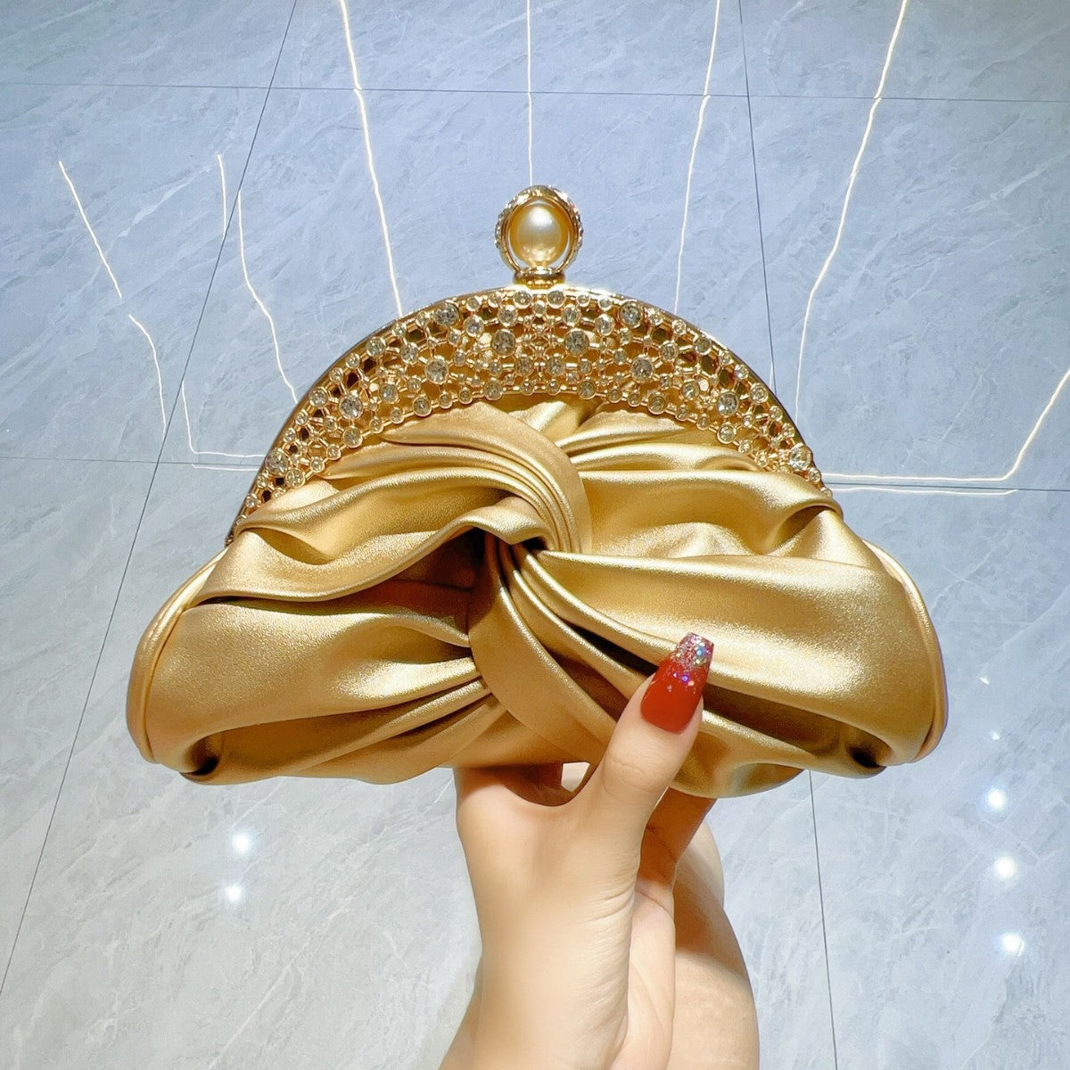 Diamond-Encrusted Pleated Clutch with Pearl Clasp — model wearing