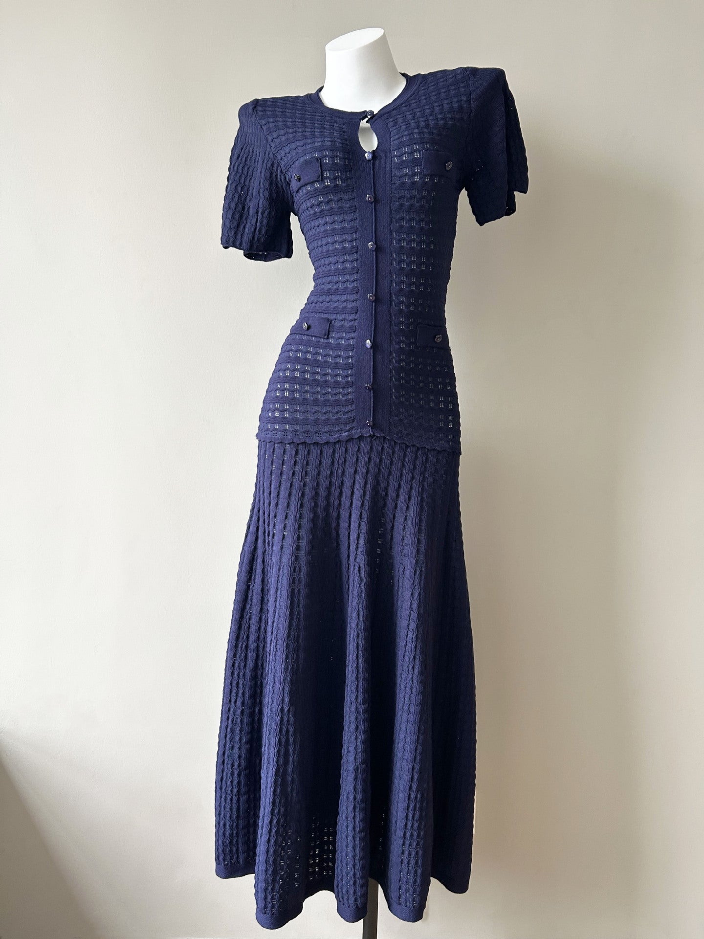 Navy pointelle knit puff-sleeve flared maxi dress on a mannequin